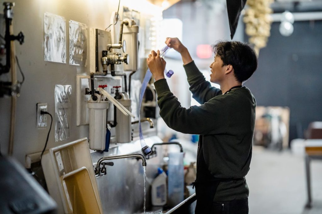 pexels photo 8113572 An adult in a darkroom setting develops film, showcasing traditional photography techniques.