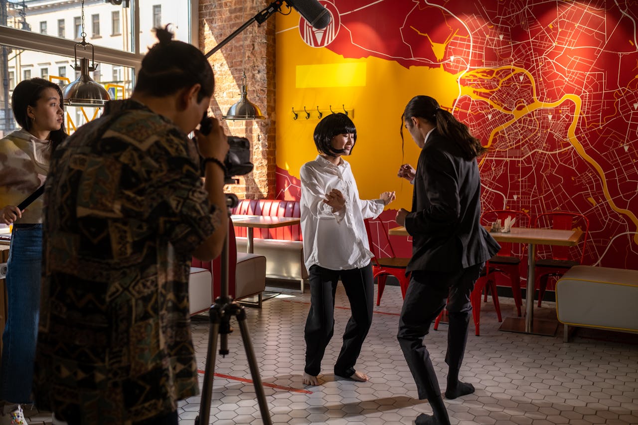 Home Filmmaking scene in a lively café, capturing actors and crew in creative action.